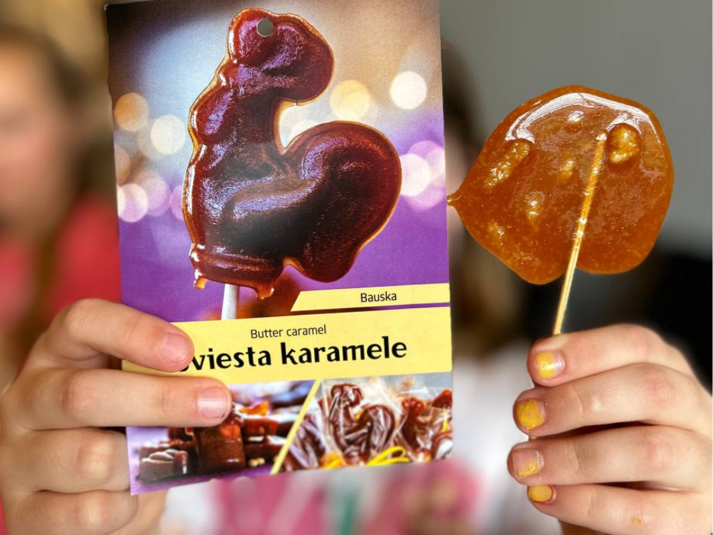 Bērns rāda cukurgailīti un Sviesta Karamele stāsta kartīti